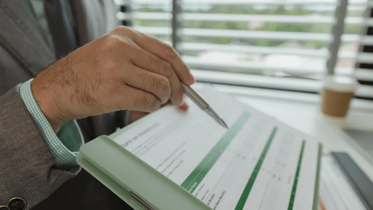 Executive reviewing a printed financial statement with a pen before an earnings release