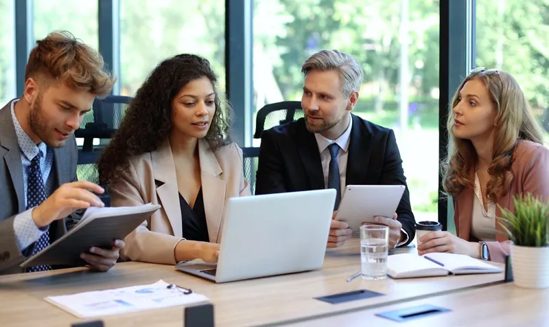 Business team reviewing a financial announcement in a meeting room