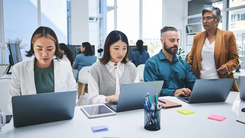 Agency team working on laptops in a bright open office